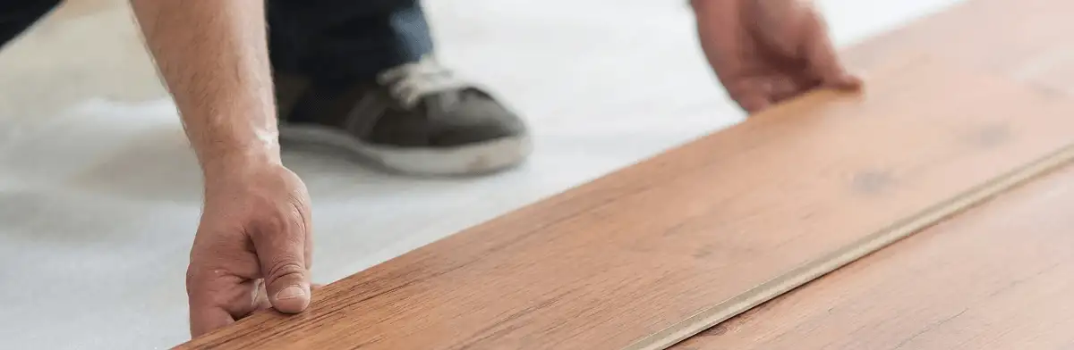 A professional installing laminate flooring in Arlington, TX